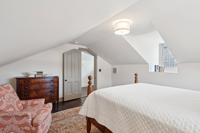 bedroom with vaulted ceiling and dark hardwood / wood-style flooring