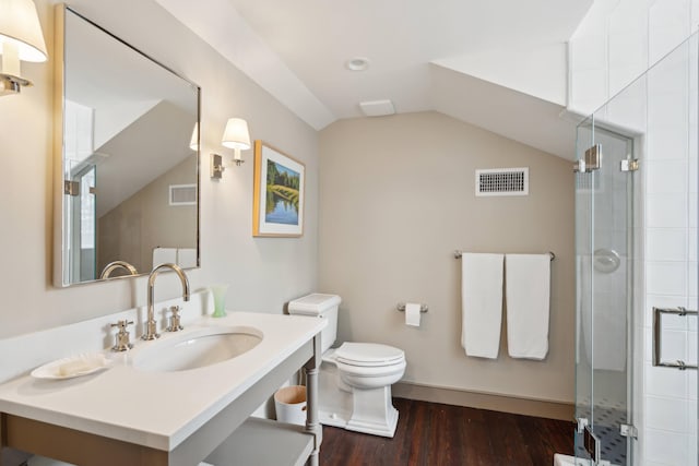 bathroom featuring hardwood / wood-style flooring, toilet, walk in shower, and vaulted ceiling