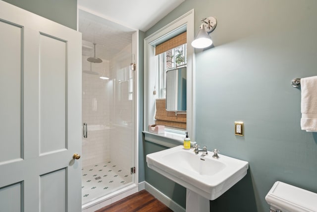 bathroom with walk in shower, sink, toilet, and hardwood / wood-style floors