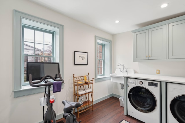 washroom with washing machine and dryer, cabinets, dark hardwood / wood-style floors, and sink