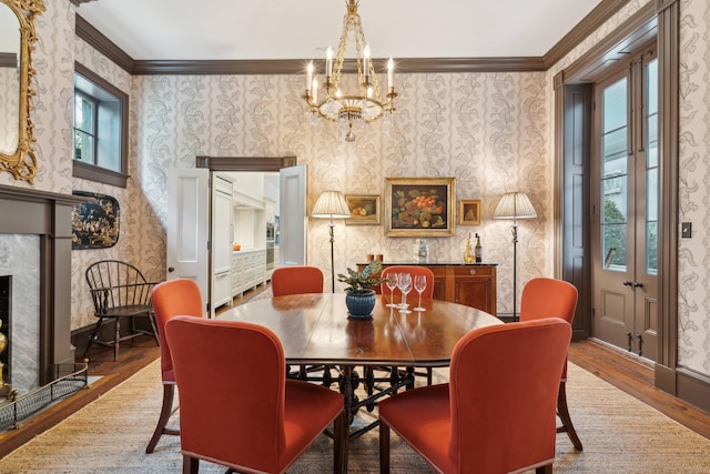 dining area featuring an inviting chandelier, ornamental molding, and hardwood / wood-style floors