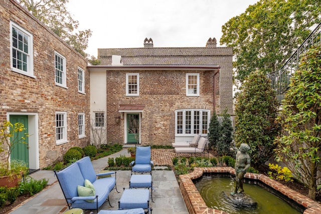 rear view of property featuring an outdoor living space and a patio