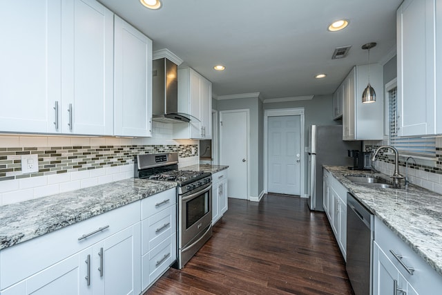 kitchen featuring white cabinets, appliances with stainless steel finishes, dark wood-type flooring, and wall chimney range hood