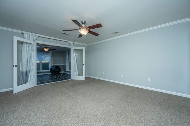 carpeted spare room with ceiling fan, ornamental molding, and a wood stove