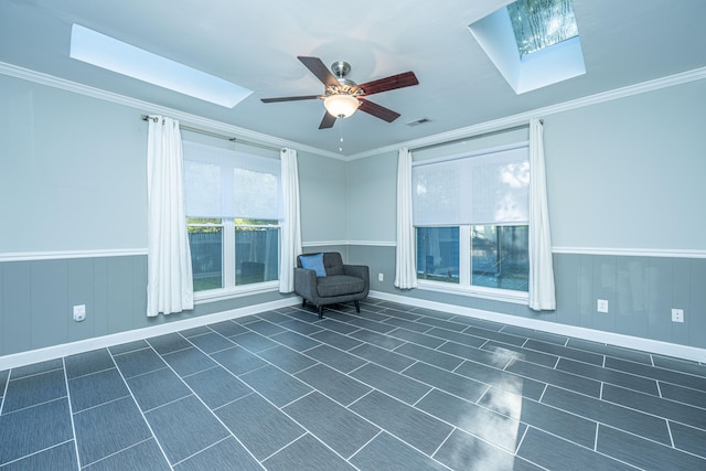 unfurnished room featuring ceiling fan, a skylight, and ornamental molding