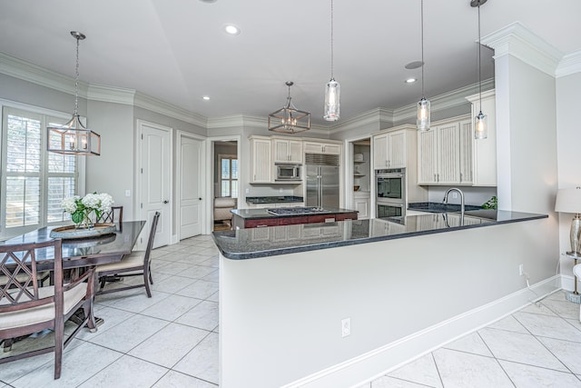 kitchen with kitchen peninsula, hanging light fixtures, built in appliances, and light tile patterned floors