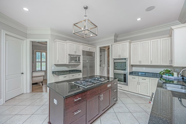 kitchen featuring built in appliances, light tile patterned floors, sink, and white cabinets