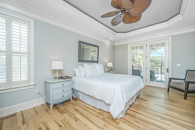 bedroom with access to outside, light wood-type flooring, a raised ceiling, ceiling fan, and ornamental molding