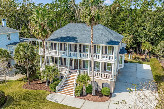 view of front of property with a balcony, covered porch, and a front yard