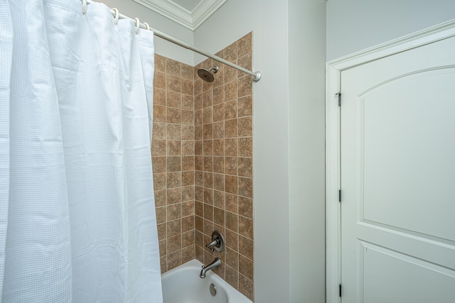 bathroom with ornamental molding and shower / tub combo