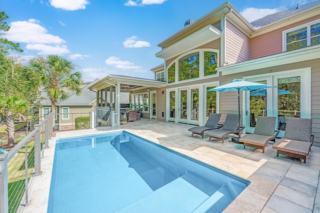 view of swimming pool with a patio and a sunroom