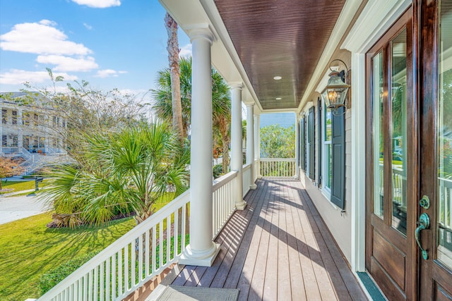 deck with a porch and a yard