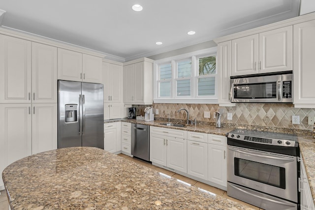 kitchen featuring light tile patterned floors, a sink, stainless steel appliances, white cabinets, and tasteful backsplash