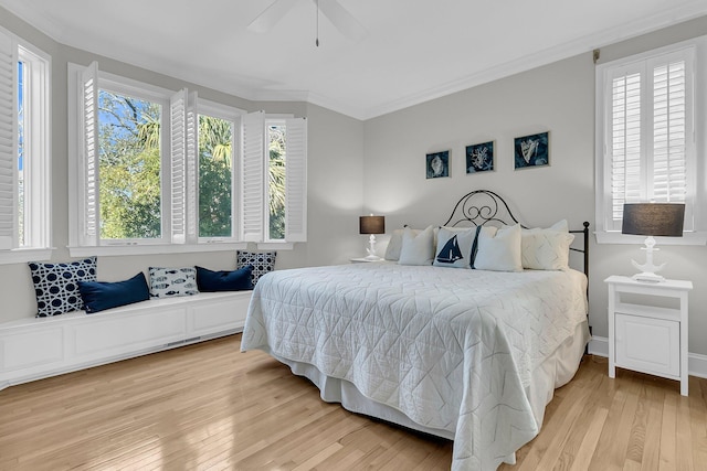 bedroom featuring light wood-style flooring, crown molding, ceiling fan, and multiple windows