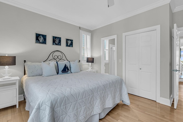 bedroom featuring baseboards, ceiling fan, light wood-style floors, a closet, and crown molding