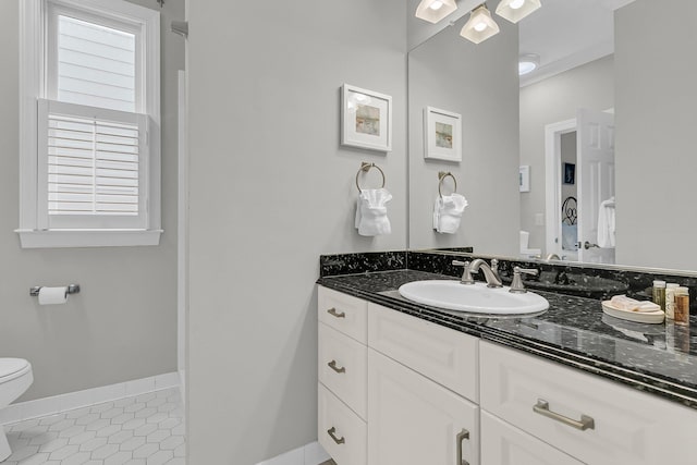 bathroom featuring vanity, a healthy amount of sunlight, baseboards, tile patterned flooring, and toilet