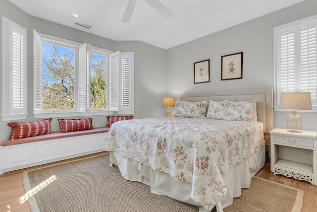 bedroom with visible vents, multiple windows, light wood-style flooring, and a ceiling fan