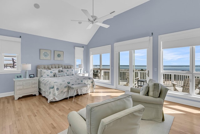 bedroom with access to exterior, visible vents, light wood finished floors, a water view, and high vaulted ceiling