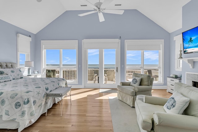 bedroom with a premium fireplace, visible vents, light wood-style floors, and access to outside