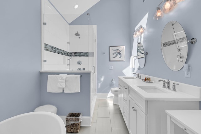 full bathroom featuring a sink, a freestanding bath, a stall shower, and double vanity