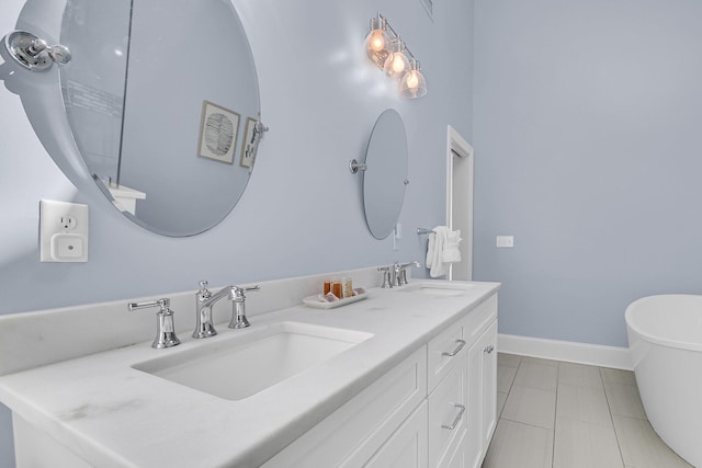 bathroom with a soaking tub, double vanity, baseboards, and a sink