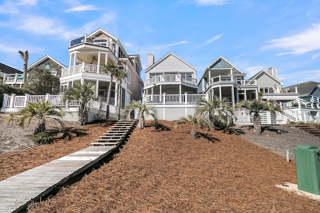 rear view of property with a balcony and ceiling fan