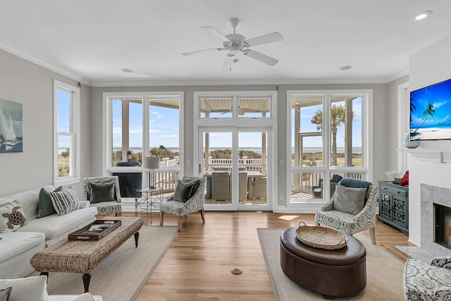 sunroom / solarium featuring a wealth of natural light, a premium fireplace, and ceiling fan