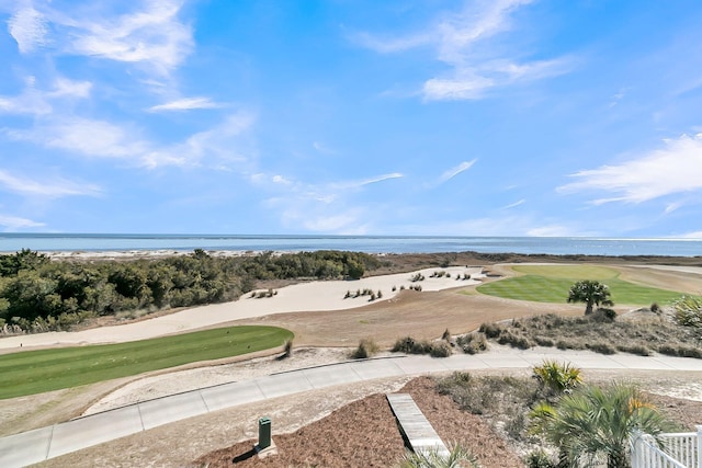 aerial view with golf course view and a water view