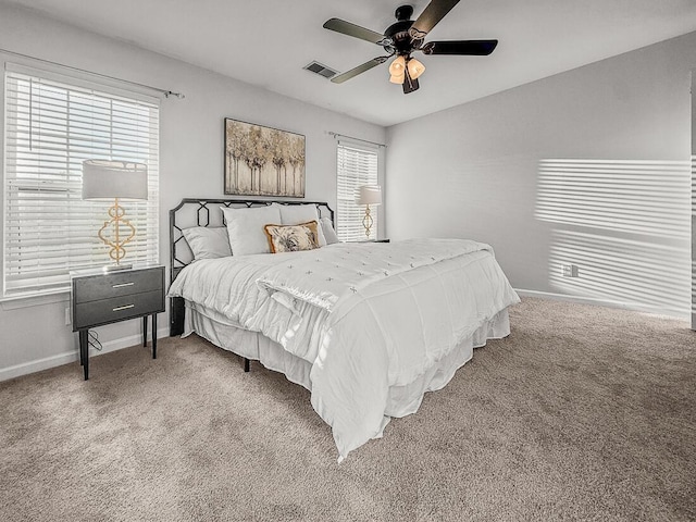 carpeted bedroom featuring multiple windows and ceiling fan