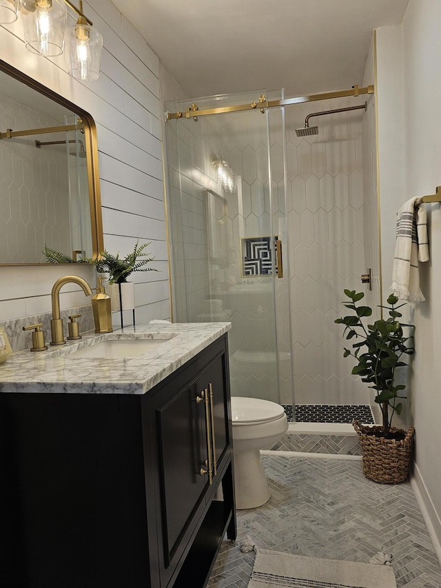 bathroom featuring walk in shower, wooden walls, vanity, and toilet