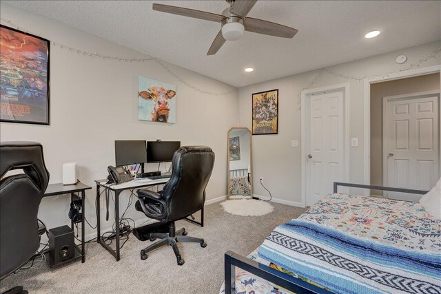 carpeted bedroom featuring ceiling fan and a textured ceiling