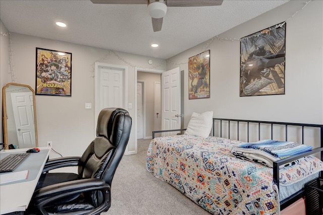 carpeted bedroom featuring ceiling fan and a textured ceiling