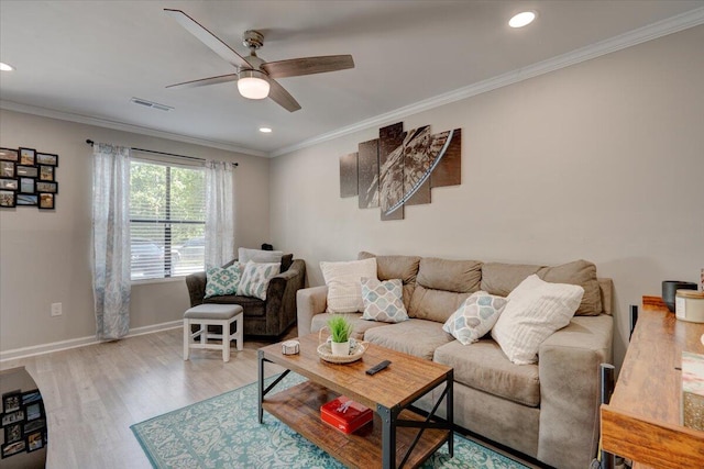 living room featuring light wood-type flooring, ceiling fan, and ornamental molding