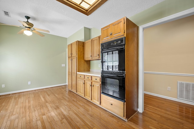 9175 Spring Branch Ct, North Charleston, SC 29406 - kitchen featuring light wood-type flooring, ceiling fan, lofted ceiling, a textured ceiling, and light countertops