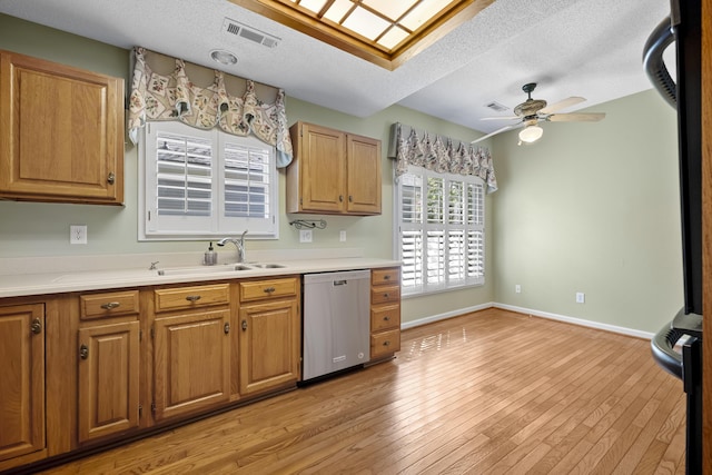 9175 Spring Branch Ct, North Charleston, SC 29406 - kitchen with stainless steel dishwasher, a ceiling fan, a textured ceiling, light countertops, and light wood finished floors