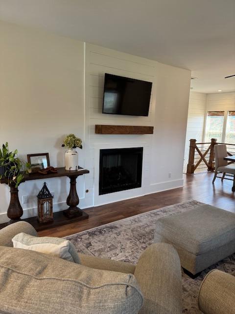 living room with wood finished floors, baseboards, and a fireplace