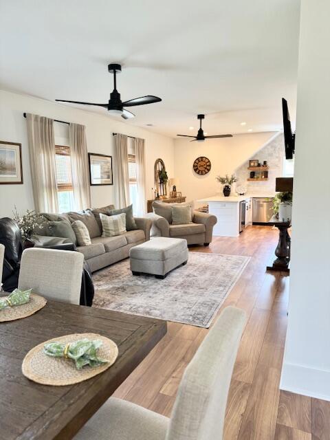 living room with ceiling fan and light wood-type flooring