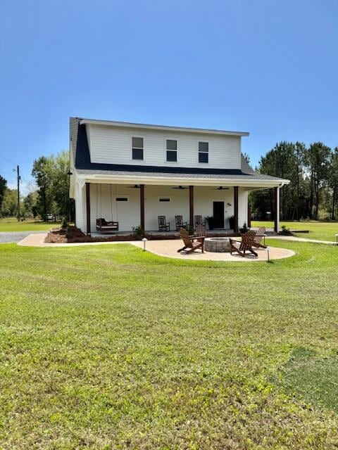 rear view of property featuring a fire pit, a patio area, a yard, and ceiling fan