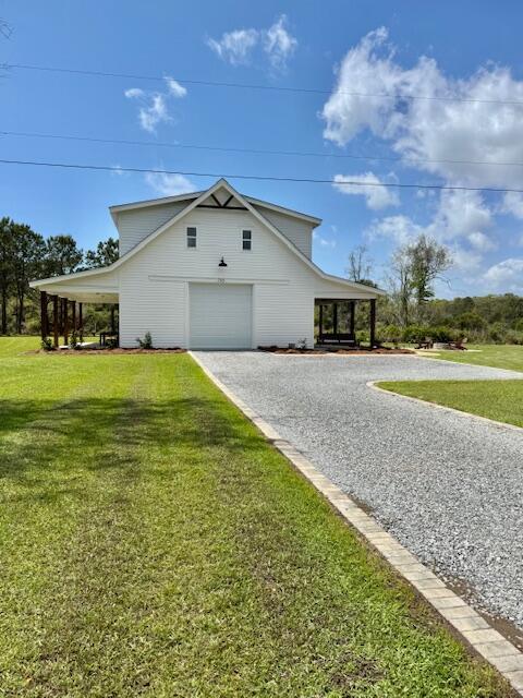 view of side of home featuring a garage, driveway, and a yard