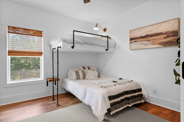 bedroom featuring wood finished floors, baseboards, and ceiling fan