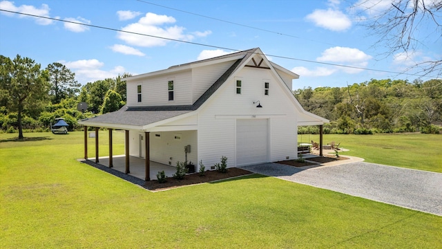 rear view of property featuring driveway, a lawn, and a shingled roof