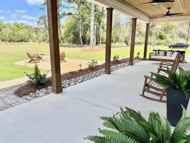 view of patio featuring a ceiling fan and view of wooded area