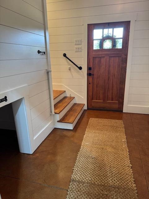foyer featuring wooden walls