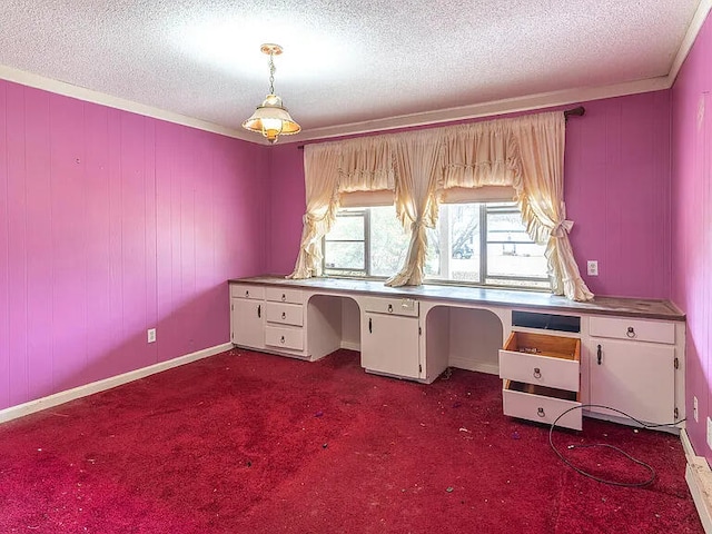 unfurnished office with built in desk, a textured ceiling, and dark colored carpet