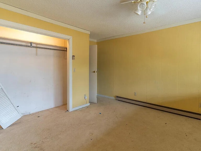 unfurnished bedroom with light colored carpet, ceiling fan, baseboard heating, a textured ceiling, and a closet