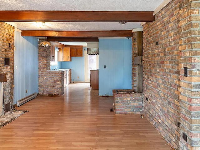 unfurnished living room featuring beam ceiling, a baseboard radiator, light hardwood / wood-style floors, and a textured ceiling