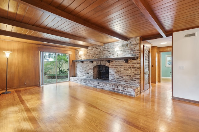 unfurnished living room with beam ceiling, wooden ceiling, hardwood / wood-style flooring, and a fireplace