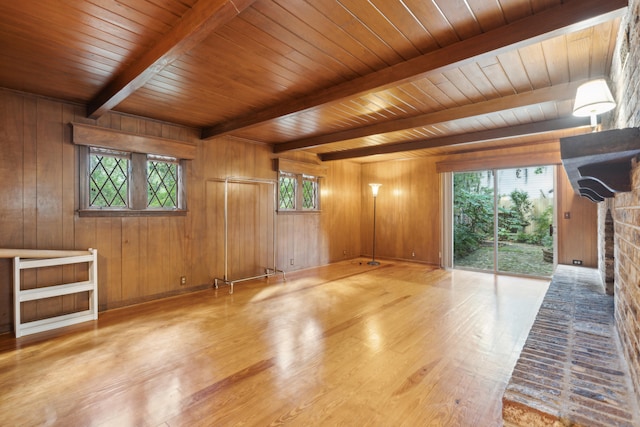 unfurnished room featuring wooden walls, beam ceiling, wooden ceiling, and light hardwood / wood-style flooring