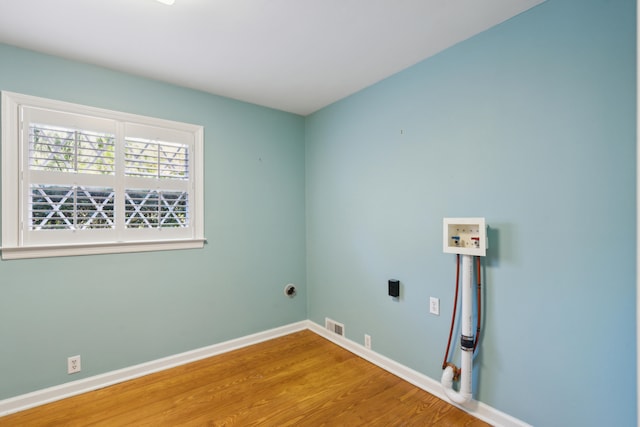 clothes washing area with hookup for a washing machine, hardwood / wood-style floors, and hookup for an electric dryer