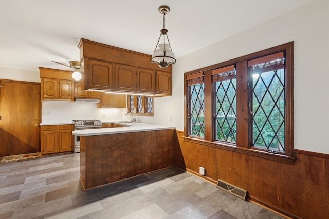 kitchen featuring stainless steel range oven, plenty of natural light, kitchen peninsula, and sink